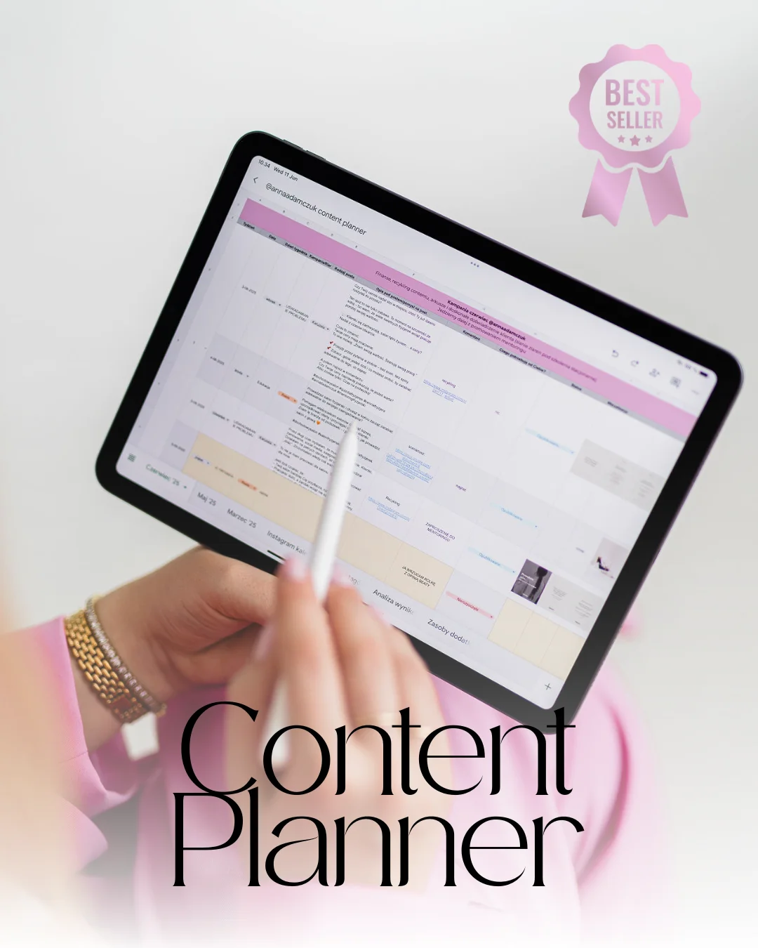 Tablet z tabelą excel trzymany przez dłonie kobiety w różowym garniturze.